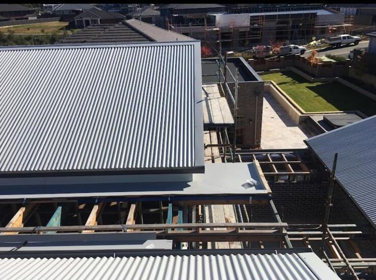 New roof sheets being installed during a full roof replacement